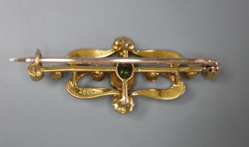 An Edwardian 15ct, split pearl and green zircon? set scroll bar brooch, 39mm, gross 4.7 grams.